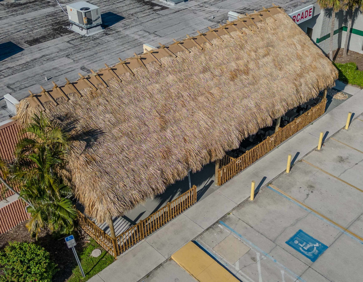 Drone view of a tiki covering a restaurant seating area